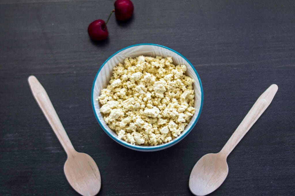 Creamy vegan cottage cheese made with tofu served in a white bowl with a sprinkle of herbs