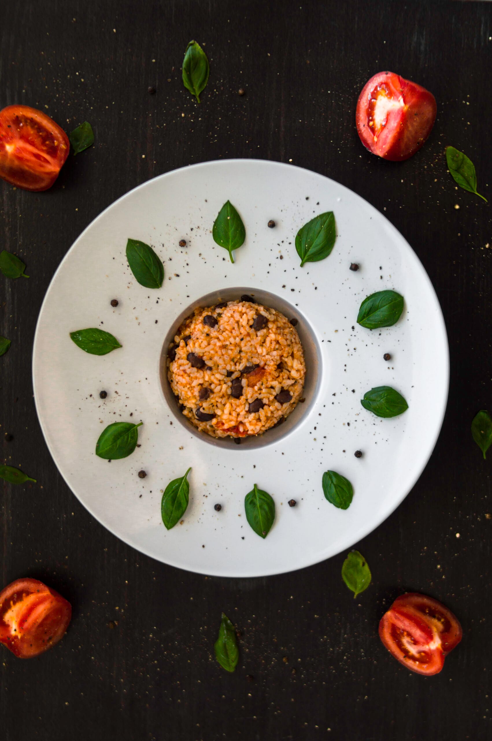Bowl of creamy risotto alla caprese with tomatoes, pesto, and herbs served warm