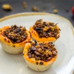 Baked vegan pizza-tofu baskets in muffin tin, topped with herbs and tomato sauce