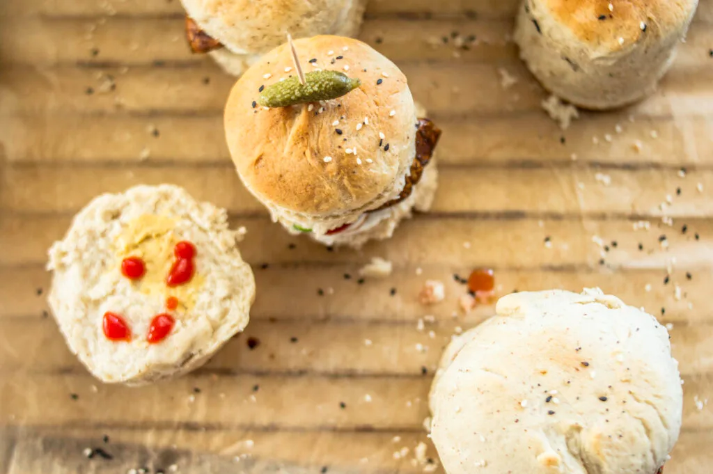 Stack of soft, golden vegan burger buns on a cooling rack, ready to be filled