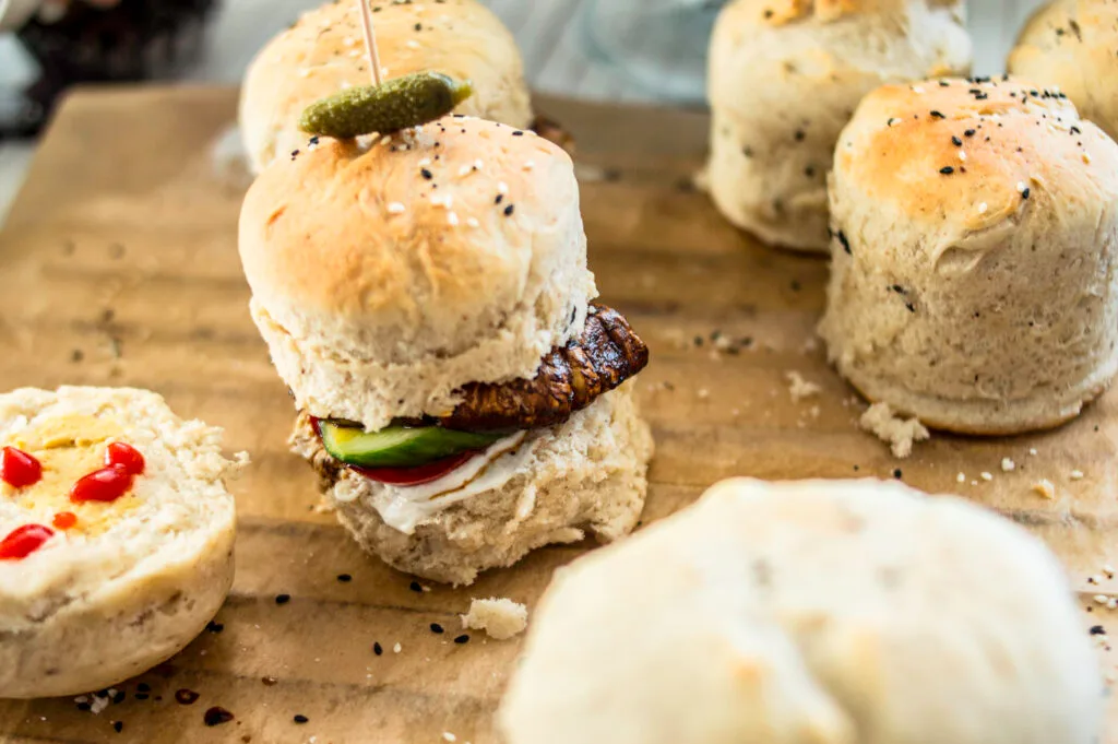 Stack of soft, golden vegan burger buns on a cooling rack, ready to be filled