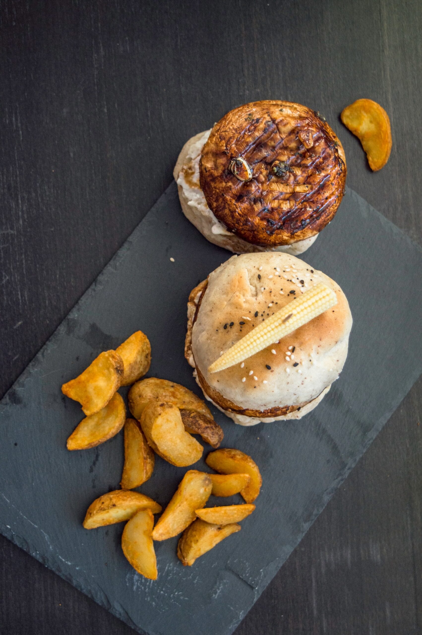 Grilled mushroom burger stacked with tomato, cucumber, and sauce on a toasted vegan bun