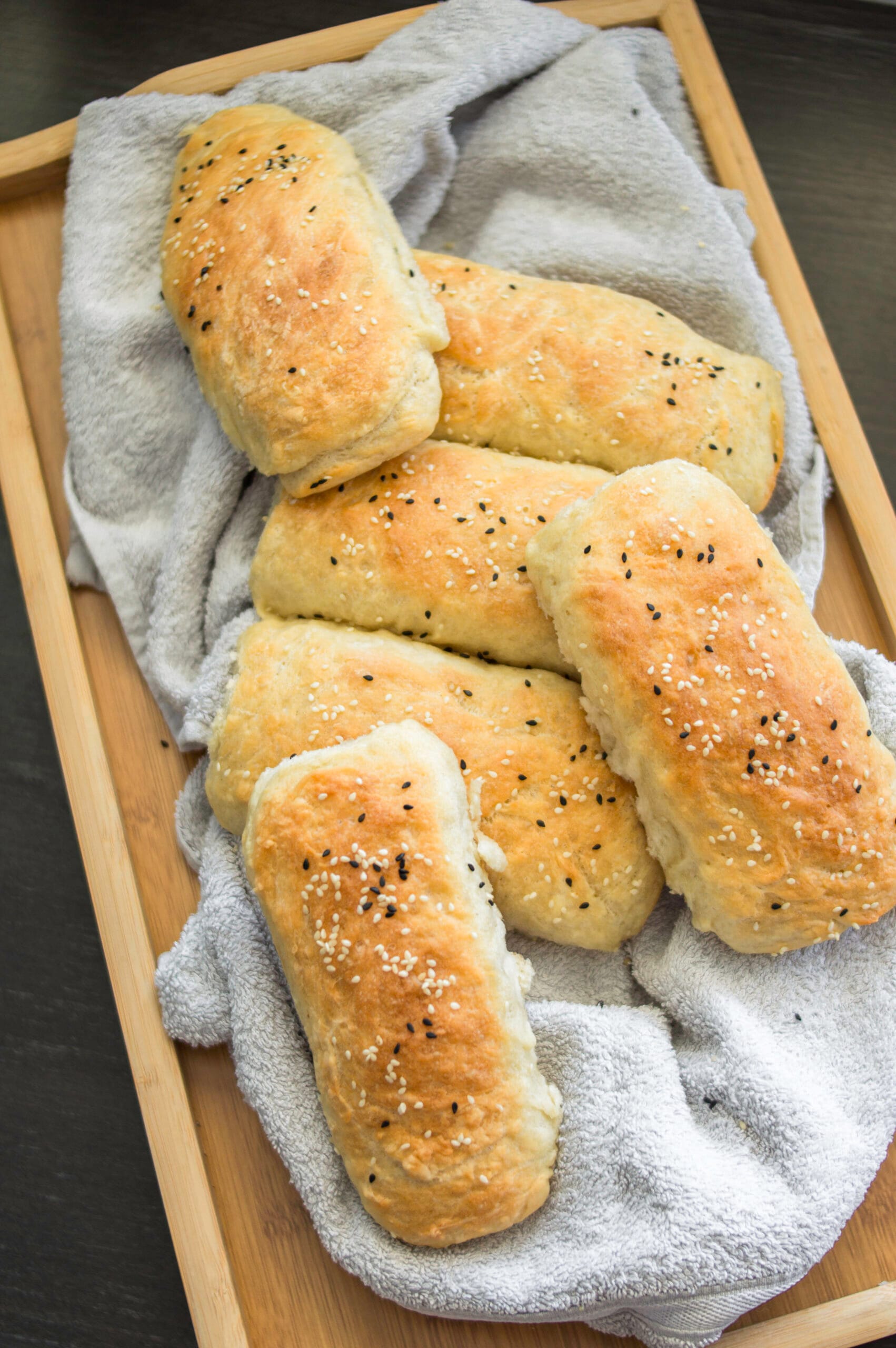 Fluffy vegan hot dog buns arranged on a tray, ready to be filled with carrot dogs or plant-based sausage.
