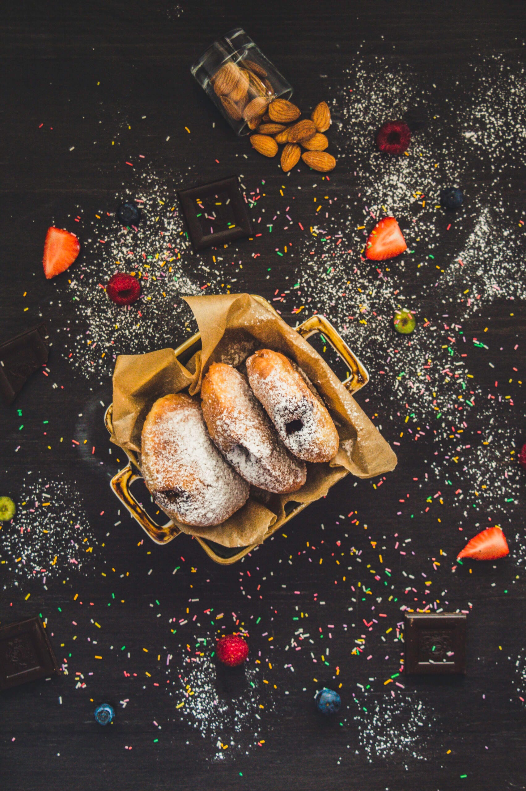 Stack of fluffy vegan donuts filled with chocolate cream, topped with powdered sugar on a cooling rack