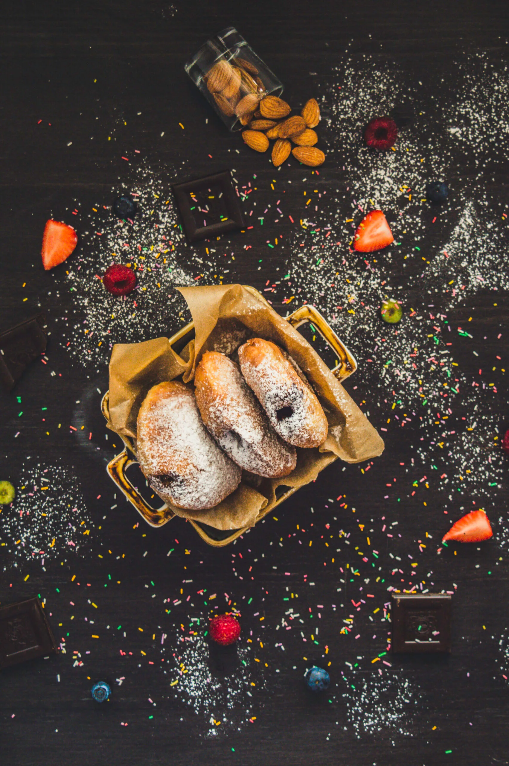 Stack of fluffy vegan donuts filled with chocolate cream, topped with powdered sugar on a cooling rack