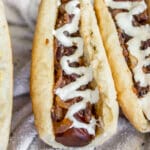 Grilled carrot hot dog in a fluffy bun with mustard, mayo, and crispy onions on top