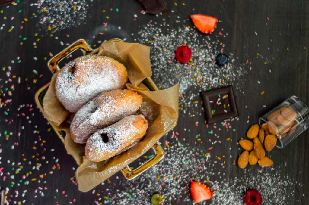 Stack of fluffy vegan donuts filled with chocolate cream, topped with powdered sugar on a cooling rack