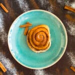 Freshly baked vegan cinnamon rolls with icing drizzle in a baking dish