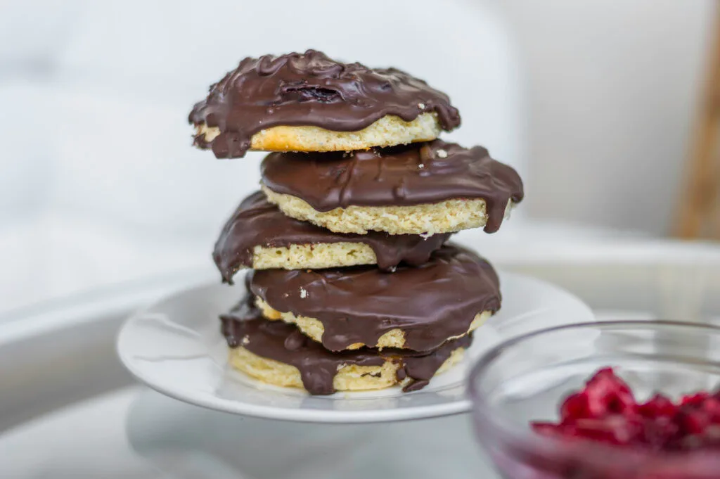 Vegan Jaffa Cakes topped with glossy chocolate and cherry jelly on a cooling rack