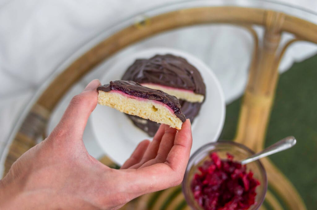Vegan Jaffa Cakes topped with glossy chocolate and cherry jelly on a cooling rack