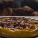 Savory Onion Tart with caramelised half-sliced onions on cheesy puff pastry golden flakey crust