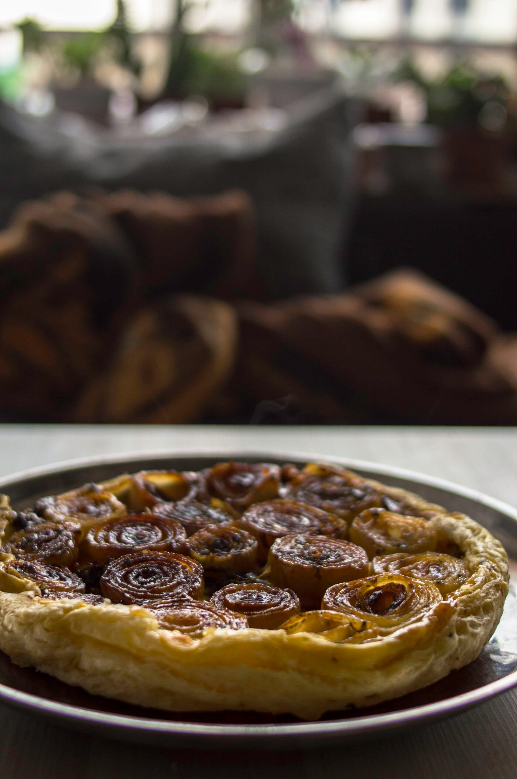Savory Onion Tart with caramelised half-sliced onions on cheesy puff pastry golden flakey crust