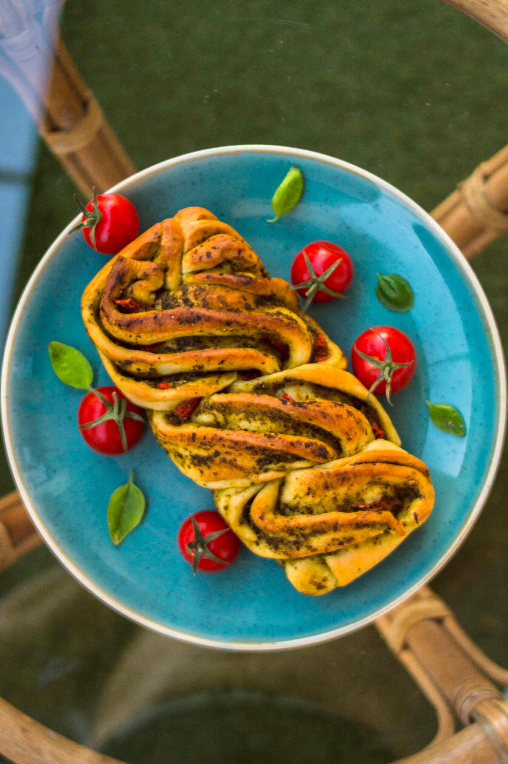 Close-up of sliced savory vegan tomato-pesto loaf with braided layers and golden crust