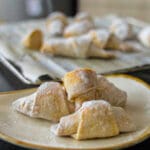 wine croissant cookies on a plate with powdered sugar