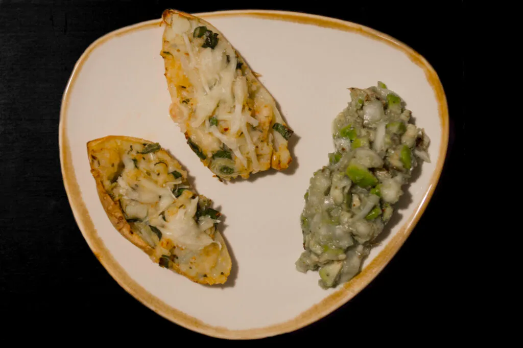 Taco potatoes stuffed with fajita-spiced mash, melted vegan cheese on top, served with a side of creamy avocado salad.